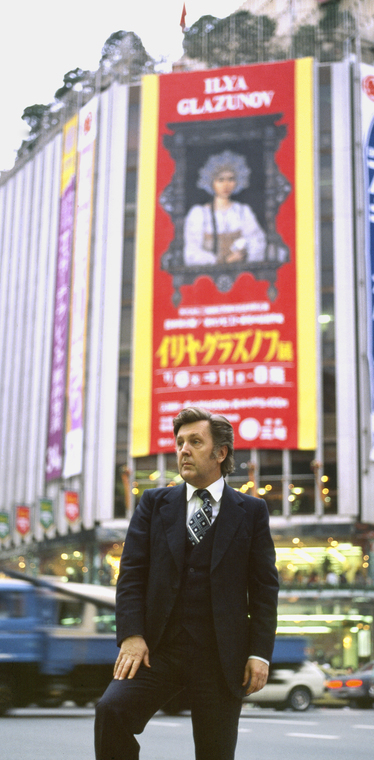 Илья Глазунов на фоне афиши его персональной выставки в Японии